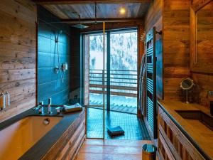 a bathroom with a shower and a tub and a sink at Chalet Caribou in Isola