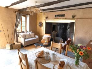 a living room with a table and a couch at Écodomaine le Vérin, Gîtes et spa - Mer, Nature & Confort - Côte d'Opale in Wierre-Effroy
