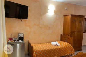 a bedroom with a bed and a tv on the wall at Affittacamere Ramina in San Giuseppe