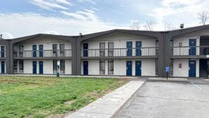 an apartment building with blue doors and a parking lot at Studio 6 Suites Lexington, Kentucky in Lexington