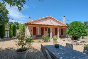 a small house with a table in front of it at Maison avec jardin proche plages & village in Gassin