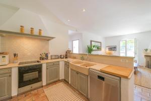 a large kitchen with a sink and a stove at Maison avec jardin proche plages & village in Gassin