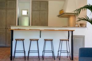 a bar with three stools and a counter top at Maison avec jardin proche plages & village in Gassin +15 photos