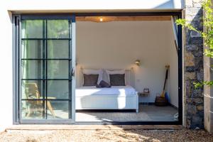 a bedroom with a bed outside of a glass door at Maison avec jardin proche plages & village in Gassin