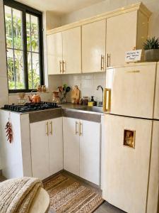 a kitchen with white cabinets and a refrigerator at BORA - Apto 101Tu espacio fuera de casa in Ibagué