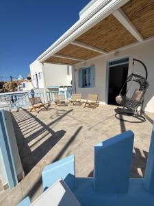 a patio with chairs and a swing on a house at Aristeidis villas in Foiníkion