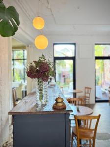 a vase of flowers sitting on a wooden table at Maison LE 2 in Solre-le-Château