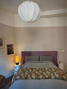 a bedroom with a large bed and a lamp at Maison LE 2 in Solre-le-Château