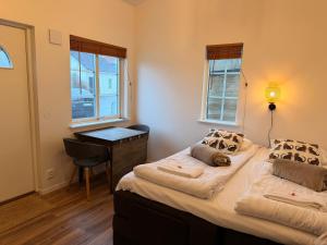 two beds in a room with a desk and windows at Vid Gekås Ullared Boende B&B in Ullared