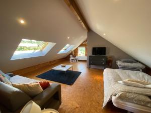 a attic room with a bed and a couch at Studio à la campagne in Jalhay