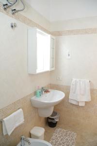 a white bathroom with a sink and a toilet at Casa Noto in Marettimo +17 photos