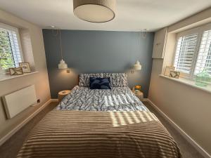 a bedroom with a bed with a striped blanket at The Hutch Devon in Longdown