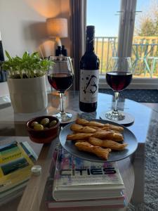 a table with a plate of food and two glasses of wine at The Hutch Devon in Longdown