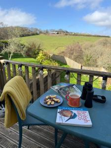 a blue table with a plate of food on a deck at The Hutch Devon in Longdown