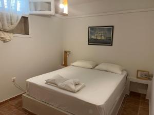 a bedroom with a white bed with two towels on it at Phoenix Cosy Home L in Livadi