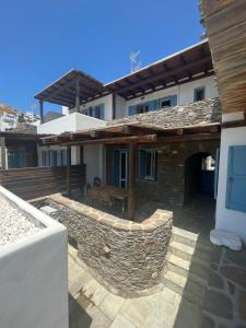 a house with a stone wall and a patio at Phoenix Cosy Home L in Livadi