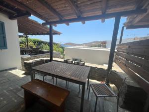 a picnic table and chairs on a patio with a view at Phoenix Cosy Home L in Livadi