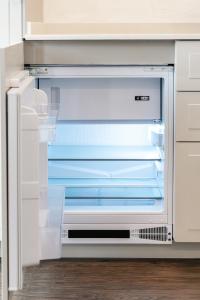 an empty refrigerator with its door open in a kitchen at Social Lodge Cabouqueira Studios in Funchal