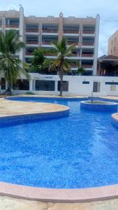 a large swimming pool in front of a building at Palm breeze seafront shanzu in Shanzu
