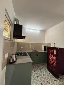 a kitchen with a stove and a refrigerator at Times Villa in Anachal