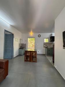 an empty living room with a door and a kitchen at Times Villa in Anachal +6 photos