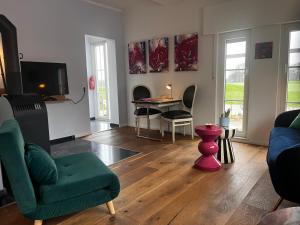a living room with a couch and chairs and a tv at Ferienwohnung Waldseite in Bad Bentheim