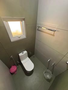 a small bathroom with a toilet and a window at Times Villa in Anachal