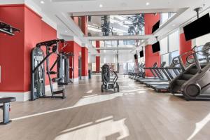 a gym with cardio equipment and red walls at Downtown Luxury Condo withPool & Skyline Views in Miami