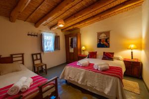 a bedroom with two beds in a room at La Rosada, Tilcara in Tilcara