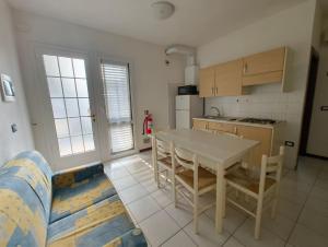 a kitchen with a table and chairs in a room at Cozy flat near the centre of Rosolina Mare in Rosolina Mare