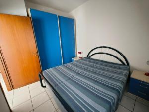 a bedroom with a bed and a blue door at Cozy flat near the centre of Rosolina Mare in Rosolina Mare