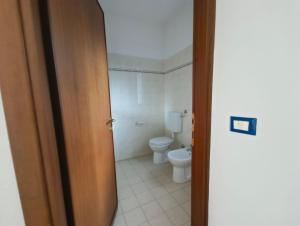 an open door to a bathroom with a toilet at Cozy flat near the centre of Rosolina Mare in Rosolina Mare