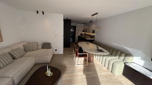 a living room with a couch and a table at Casiola - Design apartment with sea views in Knokke-Heist