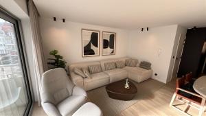 a living room with a couch and a table at Casiola - Design apartment with sea views in Knokke-Heist