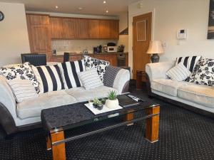 a living room with two couches and a coffee table at Courthouse View Penthouse 1 in Clifden