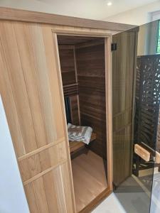a closet with wooden doors in a room at Gîtes Prestige LETENDART in Saint-Quentin-en-Tourmont +11 photos