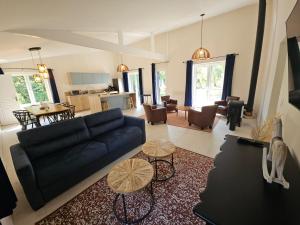 a living room with a blue couch and a table at Gîtes Prestige LETENDART in Saint-Quentin-en-Tourmont