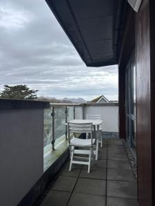 a balcony with chairs and a view of the ocean at Courthouse View Penthouse 1 in Clifden