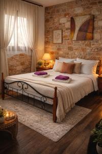 a bedroom with a large bed and a brick wall at Villa Aggeliki in Prinos