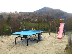 a ping pong table and a slide in a playground at Agriturismo Cascina Lella in Varzi