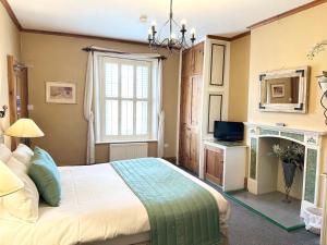a bedroom with a bed and a window and a television at Badgers Inn in Petworth