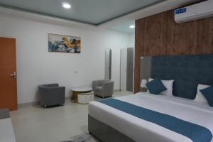 a bedroom with a large bed with a blue headboard at Gulf Star Hotel Hargeisa in Hargeysa
