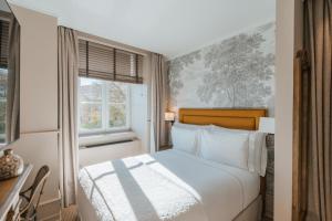 a white bedroom with a bed and a window at AlmaLusa Alfama in Lisbon +121 photos