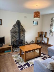 a living room with a fireplace and a couch at Braehouse cottage in Kilmory +4 photos