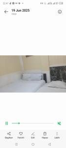 a screenshot of a picture of a bedroom with two beds at Suryawijaya in Timuran