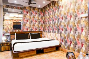 a bedroom with a bed in a room with a wall at Super Collection O Circus Avenue Road Formerly Hotel Rockstar in Kolkata +38 photos