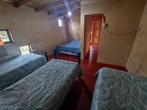 a room with two beds and a room with a door at Cabaña Mymemprende in Río Bueno