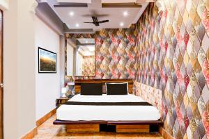 a bedroom with a bed in a room with a wall at Super Collection O Circus Avenue Road Formerly Hotel Rockstar in Kolkata