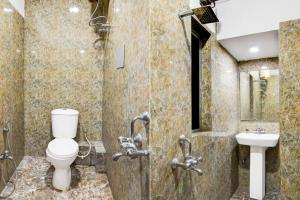 a bathroom with a toilet and a sink at Super Collection O Circus Avenue Road Formerly Hotel Rockstar in Kolkata