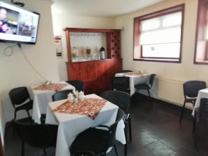a dining room with tables and chairs and a television at Hotel Bello, Andrés Bello 1166 in Temuco